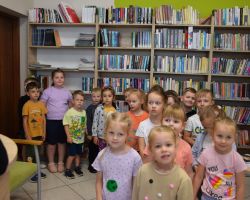 Zdjęcie grupowe dzieci z przedszkola w bibliotece.
